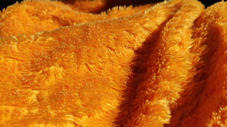 Soft yellow velvet fabric, bringing warmth and comfort, ideal for cozy household essentials.の写真素材