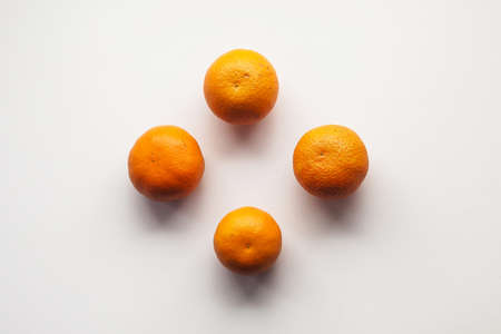 Four fresh mandarins on the white table.の写真素材