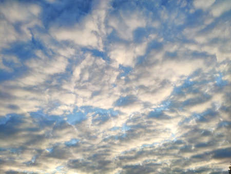 The sun shines on the clouds in the sky. Blue sky with clouds background.