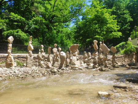 large pyramids of stones. tourists stacked a lot of stones in a pyramid on the riverbank for good luckの写真素材