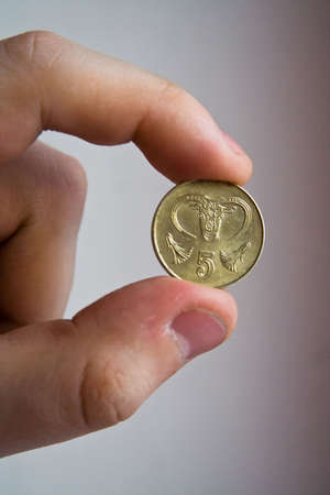 cyprus coin in the hand and finger on rose backgroundの写真素材