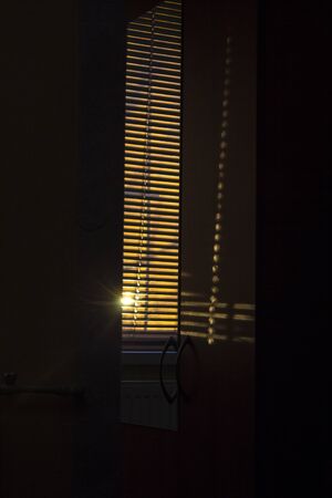 the reflection of the sun in the mirror through the blindsの写真素材