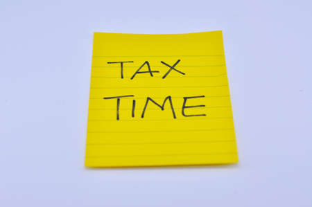 Stock Photo - tax time yellow note pad on white backgroundの写真素材