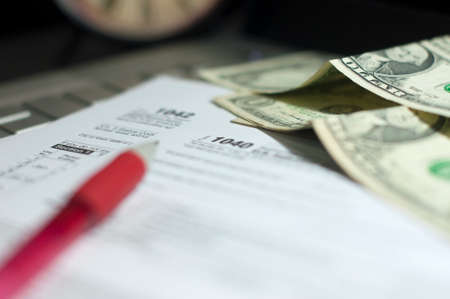 Stock Photo - Tax Form 1040 with pen, calculator and US dollars noteの写真素材