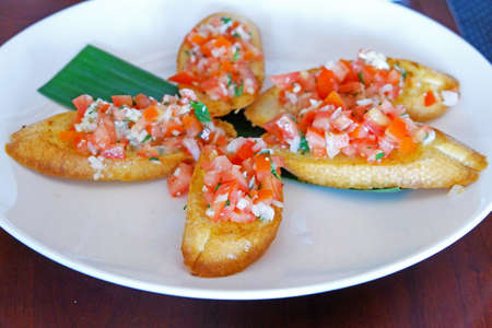 Delicious Bruschetta made with fresh tomatoes, herbs and balsamic vinegar served over toasted...