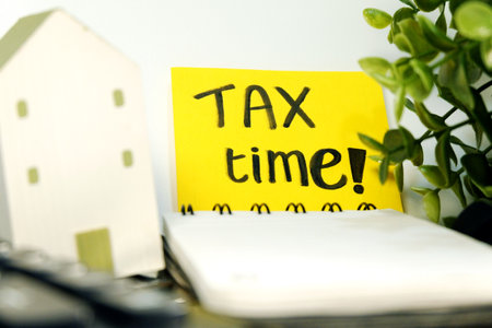 Tax time concept, yellow sticky note with text TAX TIME and houseの写真素材