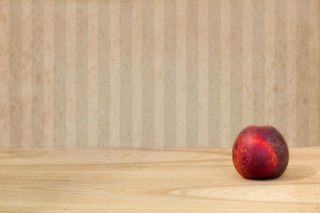 Peach on vintage wooden deck table over retro wallpaperの写真素材