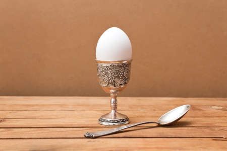 Egg in  vintage glass on wooden tableの写真素材