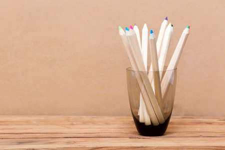 Color pencil in the glass on wooden table. 