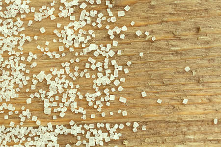 Sugar. Food background with copy space. Shiny white sugar on wooden background close up, still life.