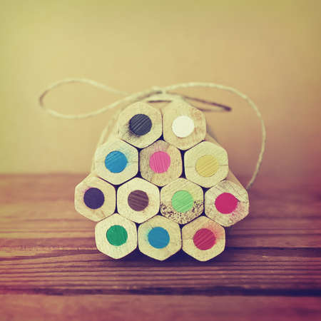 Vintage photo of colored pencils. Colored pencils tied in a heap. Toned image. の写真素材