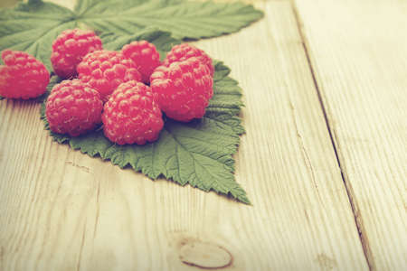 Fresh ripe raspberries with leaf on wooden table.  Agriculture, Gardening, Harvest Conceptの写真素材