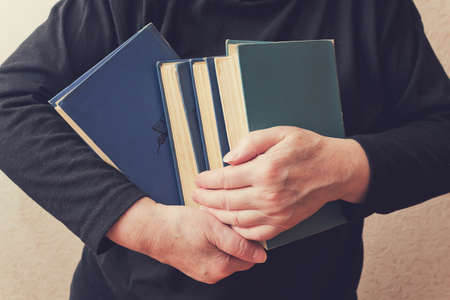 Woman holding a stack of booksの写真素材