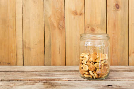 Cookies in glass jar on wooden tableの写真素材
