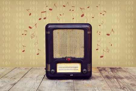 Retro radio on a wooden floor over vintage wallpaperの写真素材