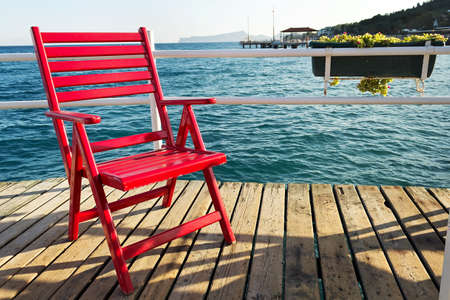 Red beach chair. Red beach chair on a pier over the seaの写真素材