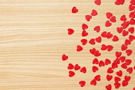 Red hearts confetti on wooden backgroundの写真素材