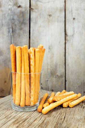 Bread sticks in a glass. Breadsticks grissini on wooden backgroundの写真素材