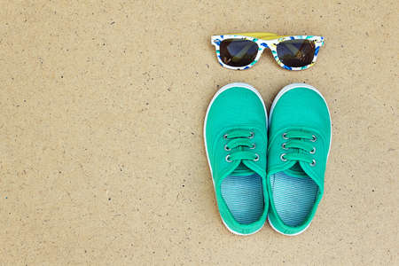 Green sneakers and sunglasses. Summer holidays. Top view trendy shoes and glasses. Hipster set....