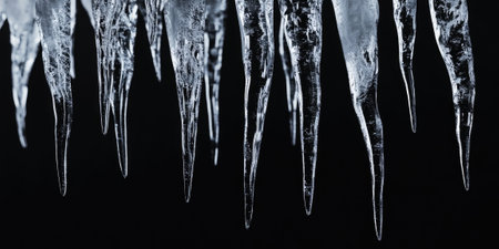 Close-Up of Realistic Transparent Icicles on Black Background - Ideal for Winter Designsの素材