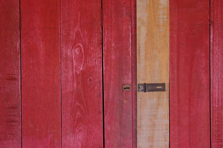 Background image of a wooden wall painted in bright red color.の写真素材