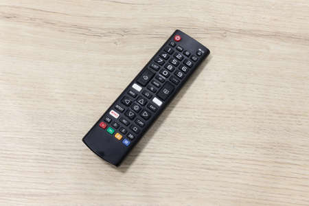 TV remote control on wooden table.