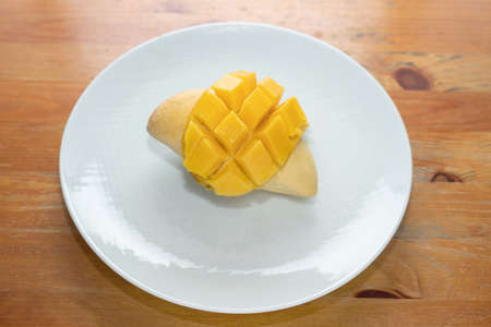 Mango yellow on dish white wood background.の写真素材