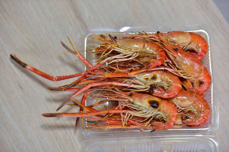 Grilled large shrimp in a plastic box on table wood.の写真素材