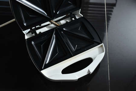 The white toaster opens and closes the lid.