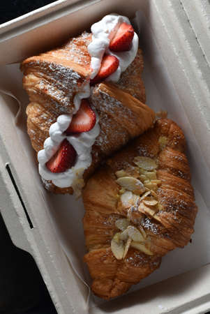Two slices of croissant bread in a paper box.の写真素材