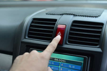 Finger on the Hazard Lights button.