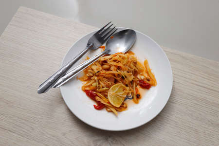 Papaya salad in a white plate and cutleryの写真素材