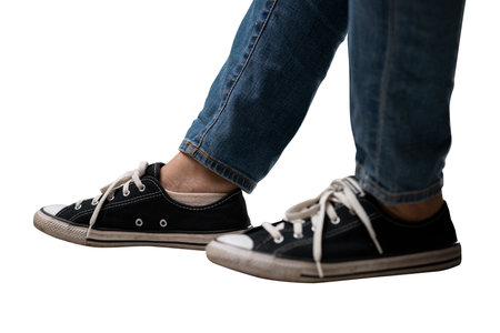 Legs wearing sneakers and jeans.