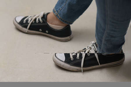 Legs wearing sneakers and jeans.の写真素材