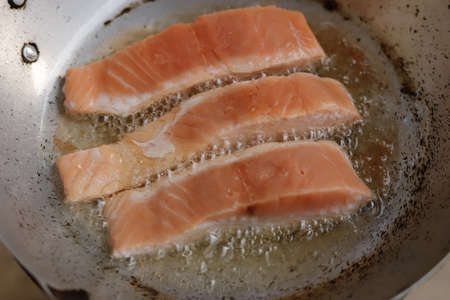 Salmon fried in oil in a panの写真素材