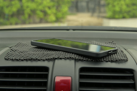Smartphone on the dashboard of a car, closeup of photoの写真素材