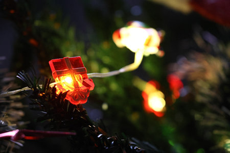 Christmas tree decoration with red and yellow lights on a dark background.の写真素材