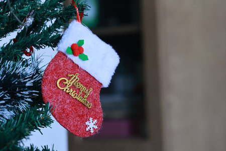 Christmas stocking hanging on a Christmas tree with the inscription merry christmasの写真素材