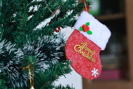 Christmas stocking hanging on a christmas tree with the inscription Merry Christmasの写真素材