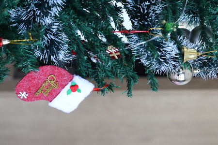 Christmas tree with Santa Claus hat and gift box on blurred background.の写真素材