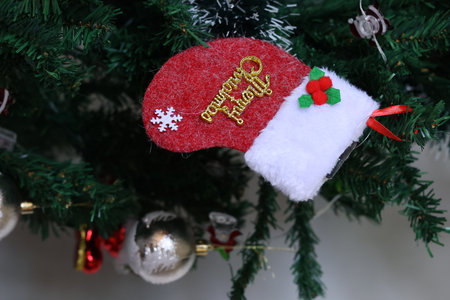 Santa Claus hat hanging on the Christmas tree, Christmas and New Year backgroundの写真素材
