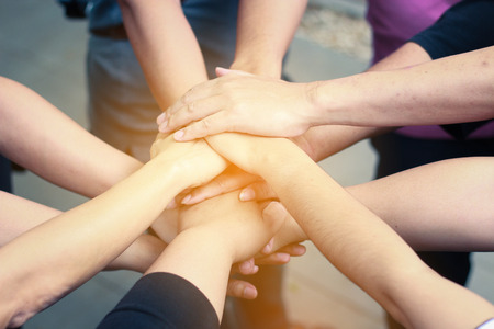 Members with stack of hands showing victory and teamwork.Friends team putting hands up for new startup in creative officeの写真素材