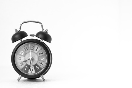 old alarm clock on white background,red light,black and white image,with copy space