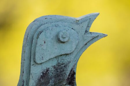 rusty metal sculpture of bird outdoors