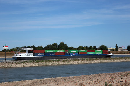 Tiel, The Netherlands 8-30-2022: Container transport by water on the river Waal past the town of Tiel in the Netherlandsのeditorial素材