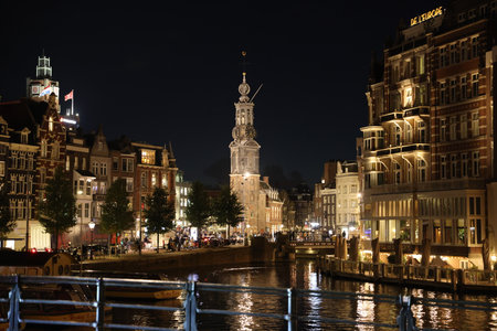 The Munttoren in Amsterdam, The Netherlands, seen from the Amstel at nightのeditorial素材