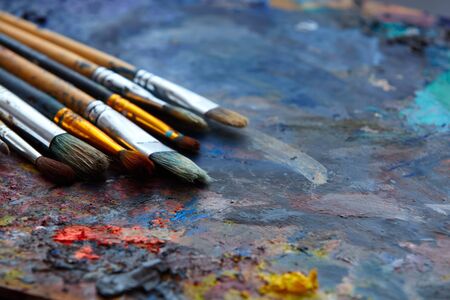 Paint brushes on a palette close up.