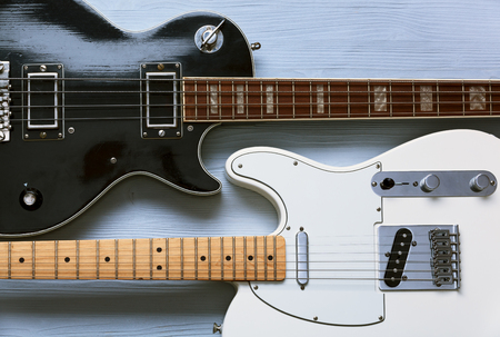 Two guitars on a light wooden board. Top view.の写真素材