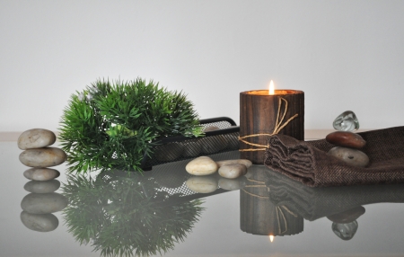 candle, stones and plant on a glass table displaysの写真素材