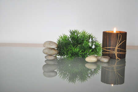 candle, stones and plant on a glass table displaysの写真素材